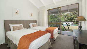 A hotel room with two beds, a large window, and a view of the outdoors. - Kananda (Noosa Heads)