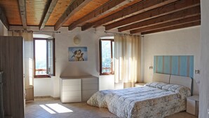Ein Schlafzimmer mit einem Bett, einem Schminktisch, einem Schreibtisch und einem Bild an der Wand.