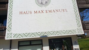 Une enseigne portant le nom « HAUS MAX EMANUEL » et un blason.