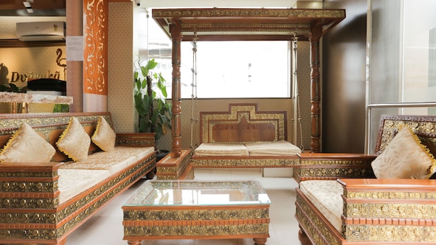 A traditional room with ornate furniture, including a canopy bed and matching sofas, and a glass coffee table. - Treebo Trend Dvaraka Inn (Bengaluru)
