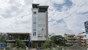 A modern hotel with a central tower, multiple balconies, and a ground-level entrance. - Treebo Trend Dvaraka Inn (Bengaluru)