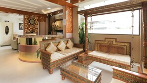 A spacious lobby with a reception desk, a sofa set, and a hanging swing chair. - Treebo Trend Dvaraka Inn (Bengaluru)