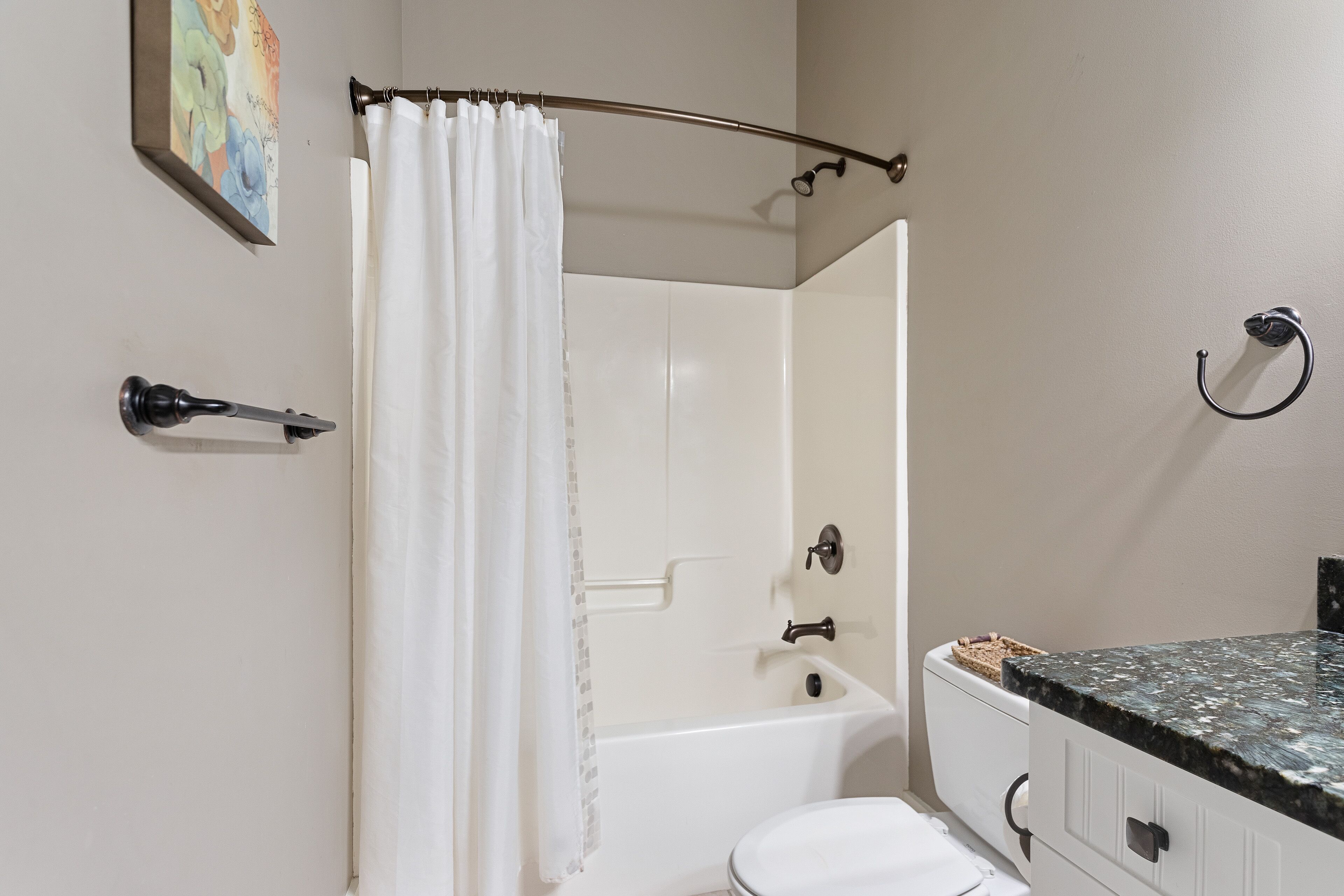 A bathroom with a bathtub, toilet, and a shower curtain.