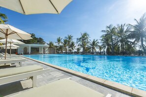Una piscina al aire libre, sombrillas, tumbonas