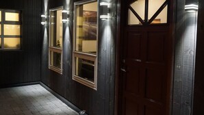 A hallway with wooden walls and a dark wooden door. - Dalakot (Budardalur)
