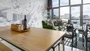 En modern inredning med ett träbord, en grön soffa och en tapet med ett stadsmotiv.