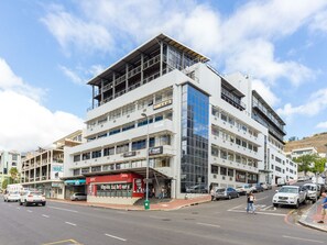 A multi-story commercial building with a KFC restaurant on the ground floor, a TWF sign, and a visible staircase leading to an upper level. - Designer De Waterkant Pad (Cape Town)