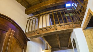 Un escalier en bois, doté d’une rampe également en bois, mène à un niveau supérieur.