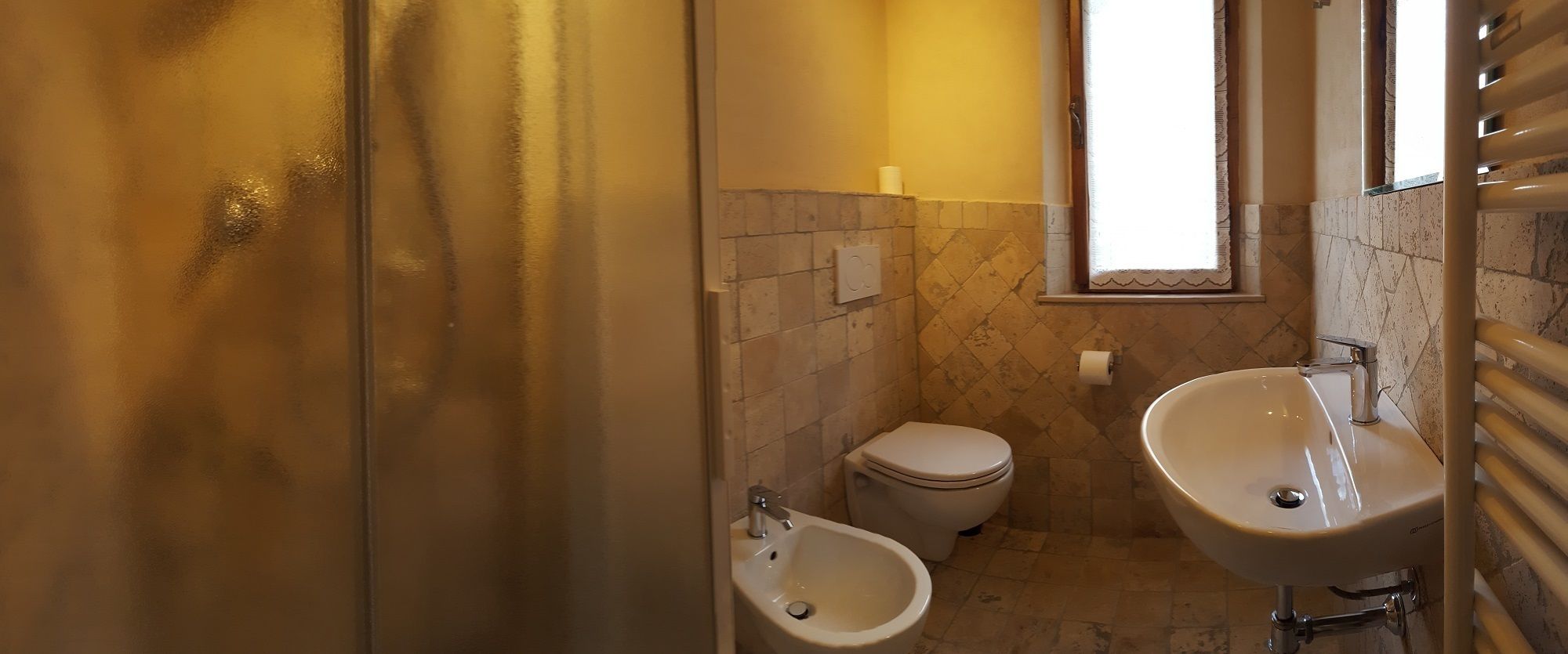 Une salle de bain équipée d’un bidet, de toilettes et d’un lavabo.
