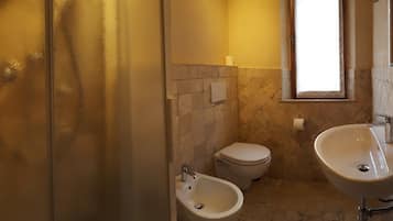 Une salle de bain équipée d’un bidet, de toilettes et d’un lavabo.