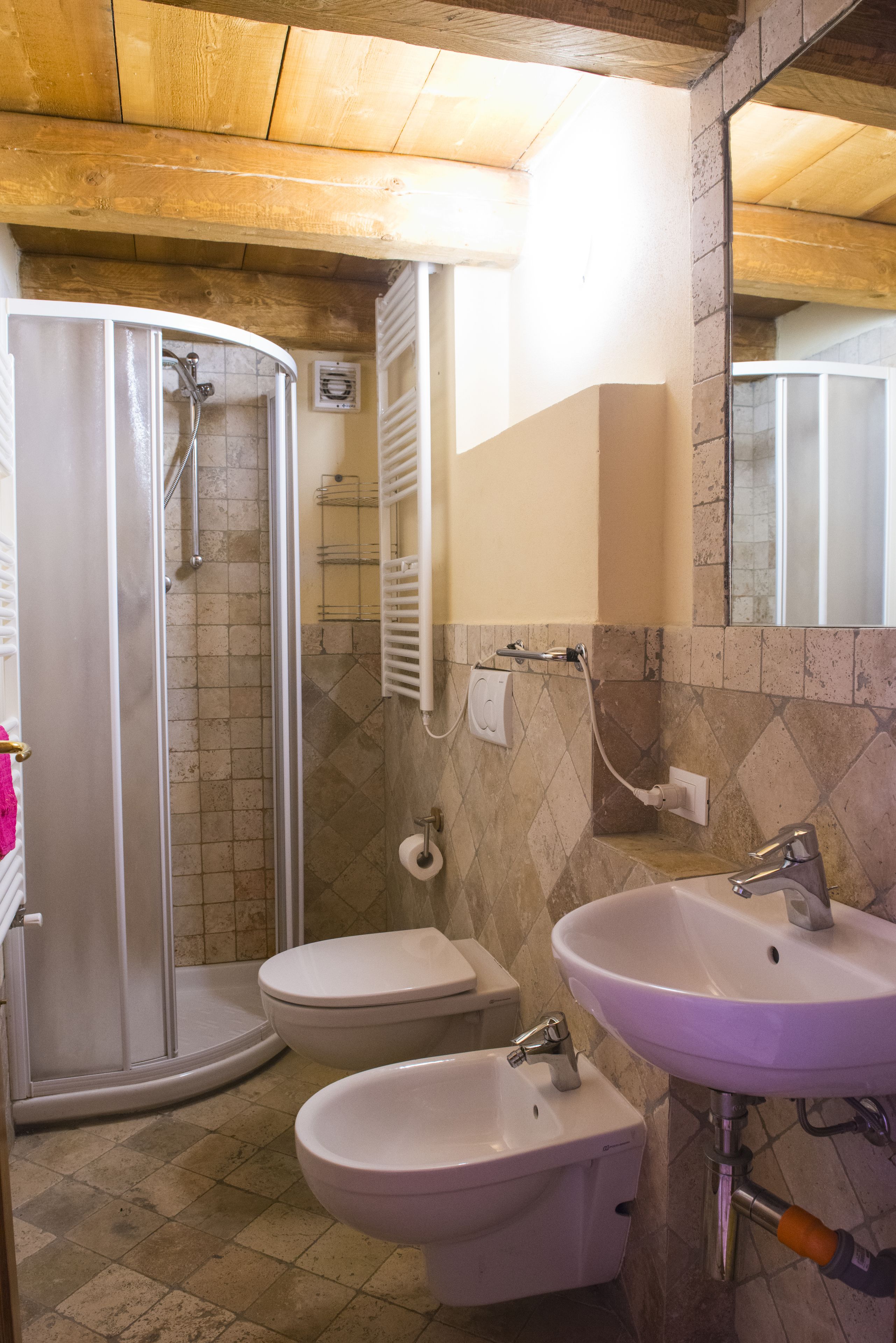 Ein Badezimmer mit Dusche, Toilette und zwei Waschbecken.