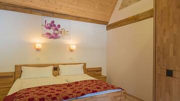 Een slaapkamer met een houten bed, twee bedlampen en een houten plafond.