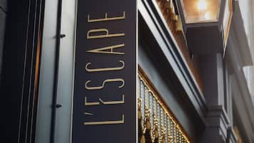 A sign with the word "ESCAPE" hanging from a building.