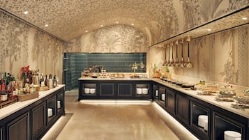 Uma cozinha espaçosa com uma bancada grande, armários escuros e teto decorativo.