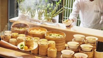 A buffet setup with various food items and bamboo steamers.
