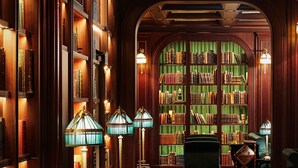 A library with wooden bookshelves, green curtains, and multiple floor lamps. - L’Escape, a Luxury Collection Hotel, Seoul Myeongdong (Seoul)