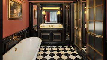 A luxurious bathroom with a large bathtub, a vanity with a mirror, and a checkered floor.