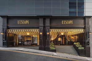 A hotel entrance with 'L'ESCAPE' signage, a grand staircase, and decorative lighting. - L’Escape, a Luxury Collection Hotel, Seoul Myeongdong (Seoul)