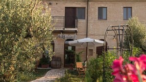 A building with a brick facade, a balcony, and a sign that reads "Bassin". - Agriturismo Bassarì (Recanati)