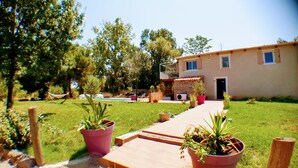 A house with a pool, potted plants, and a wooden deck. - Villa Alyzea (Bessan)