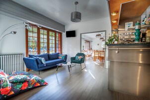 Una sala de estar moderna con un sofá azul, un sillón verde y una mesa de centro.