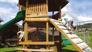 A wooden play structure with a slide and climbing elements. - Hotel Oberhofer (Rio di Pusteria)