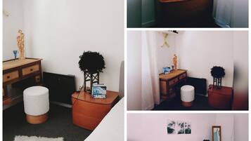 Een moderne hotelkamer met een bed, een bureau met een computer, een klein tafeltje met een lamp en een decoratief beeldje.
