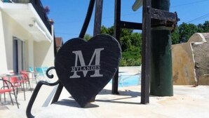 A black heart-shaped sign with the letters "M" and "M" and the word "MYLANDES" on it. - Le Clos des Mylandes (Dax)