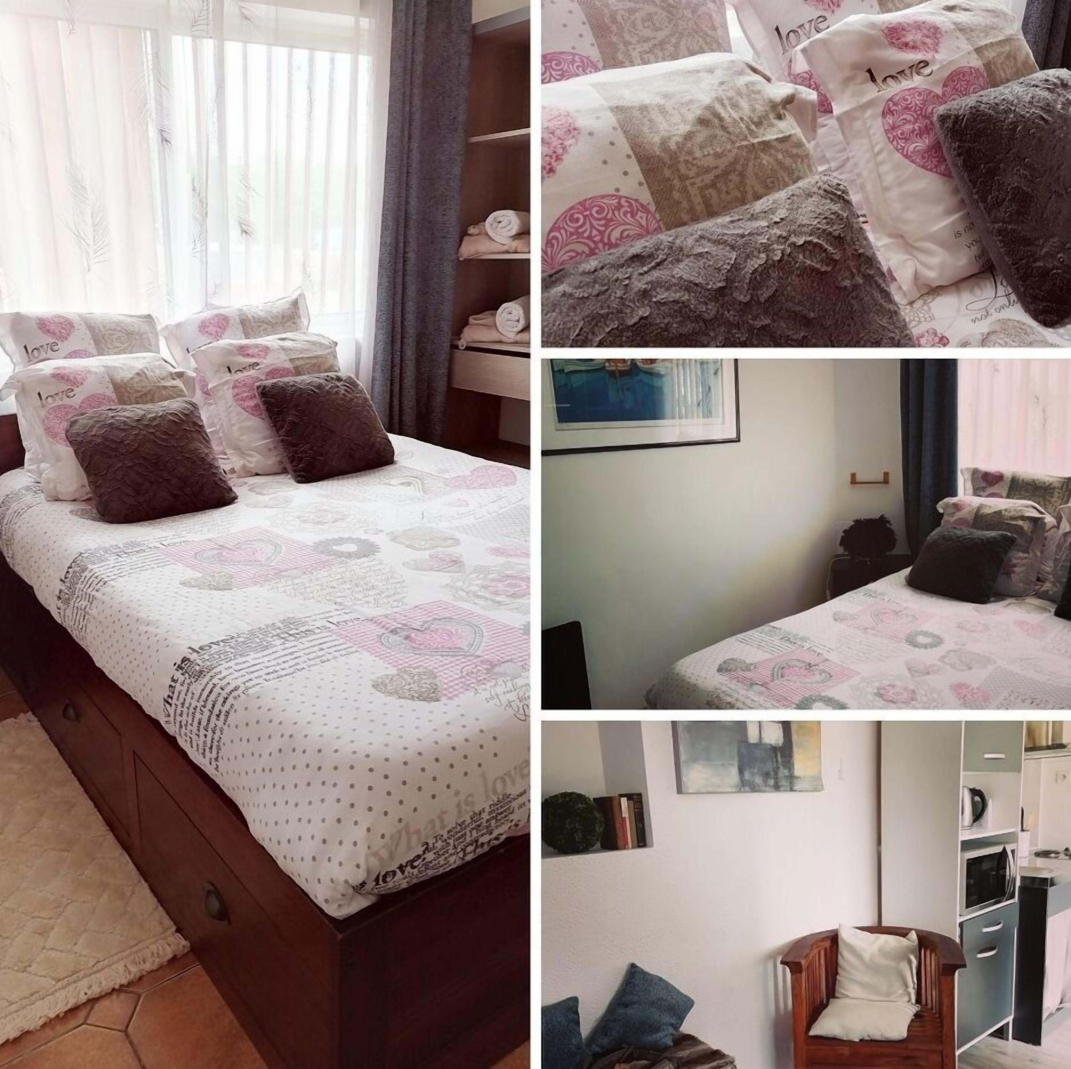 A bedroom with a bed, pillows, and a bedside table.