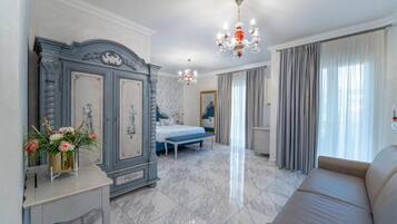 Un dormitorio con cama, cómoda, candelabro y una ventana grande con cortinas.
