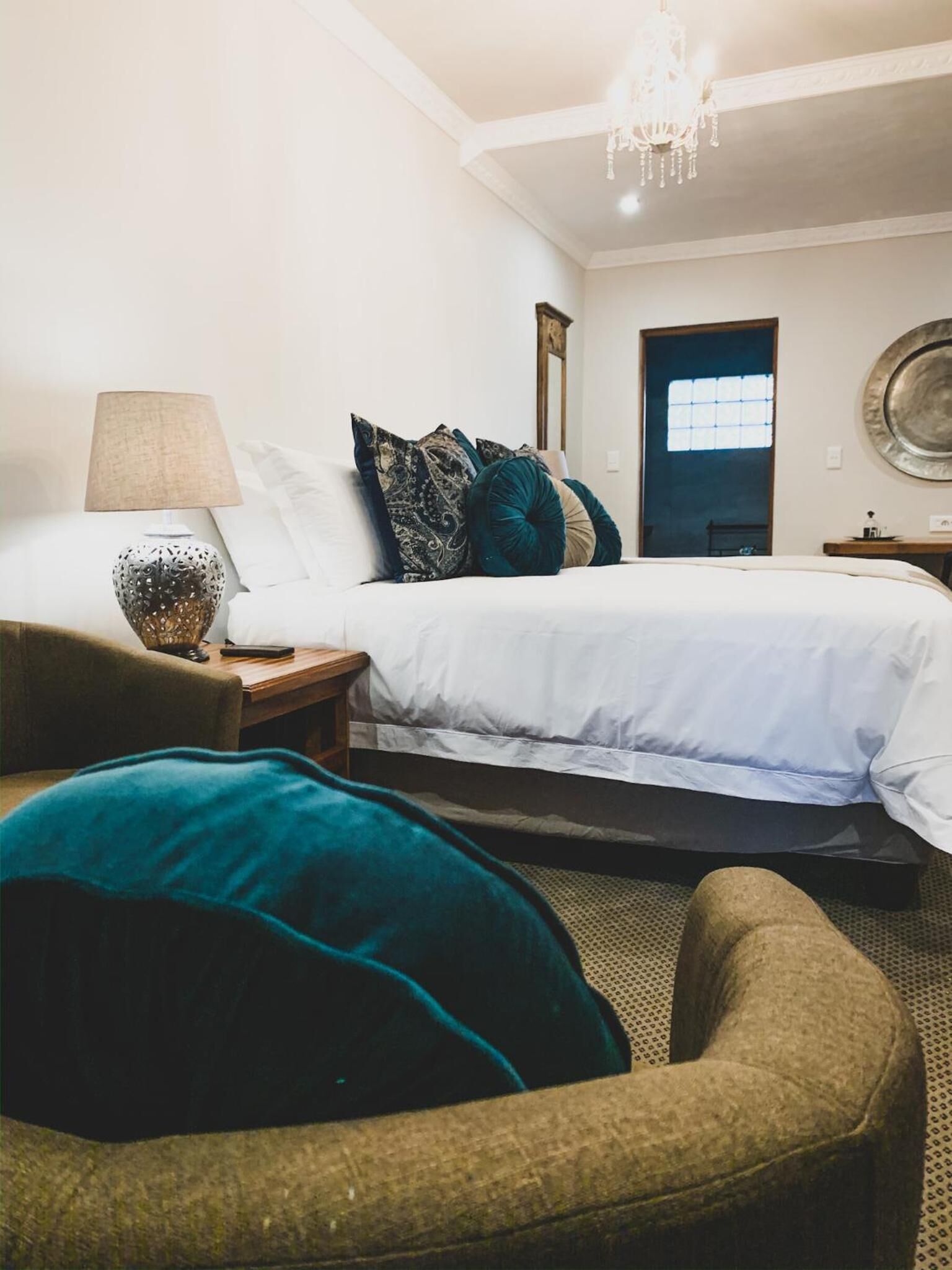 Ein Schlafzimmer mit Bett, Nachttisch, Lampe und Stuhl.