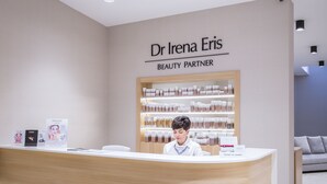 Un mostrador de recepción con un cartel que dice "Dr. Irina Eris Beauty Partner" y una exhibición de productos de belleza detrás.