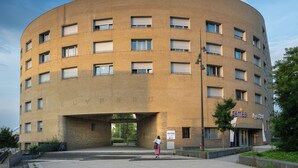 Un edificio moderno con fachada curva, múltiples ventanas y un cartel que indica que es un hotel.