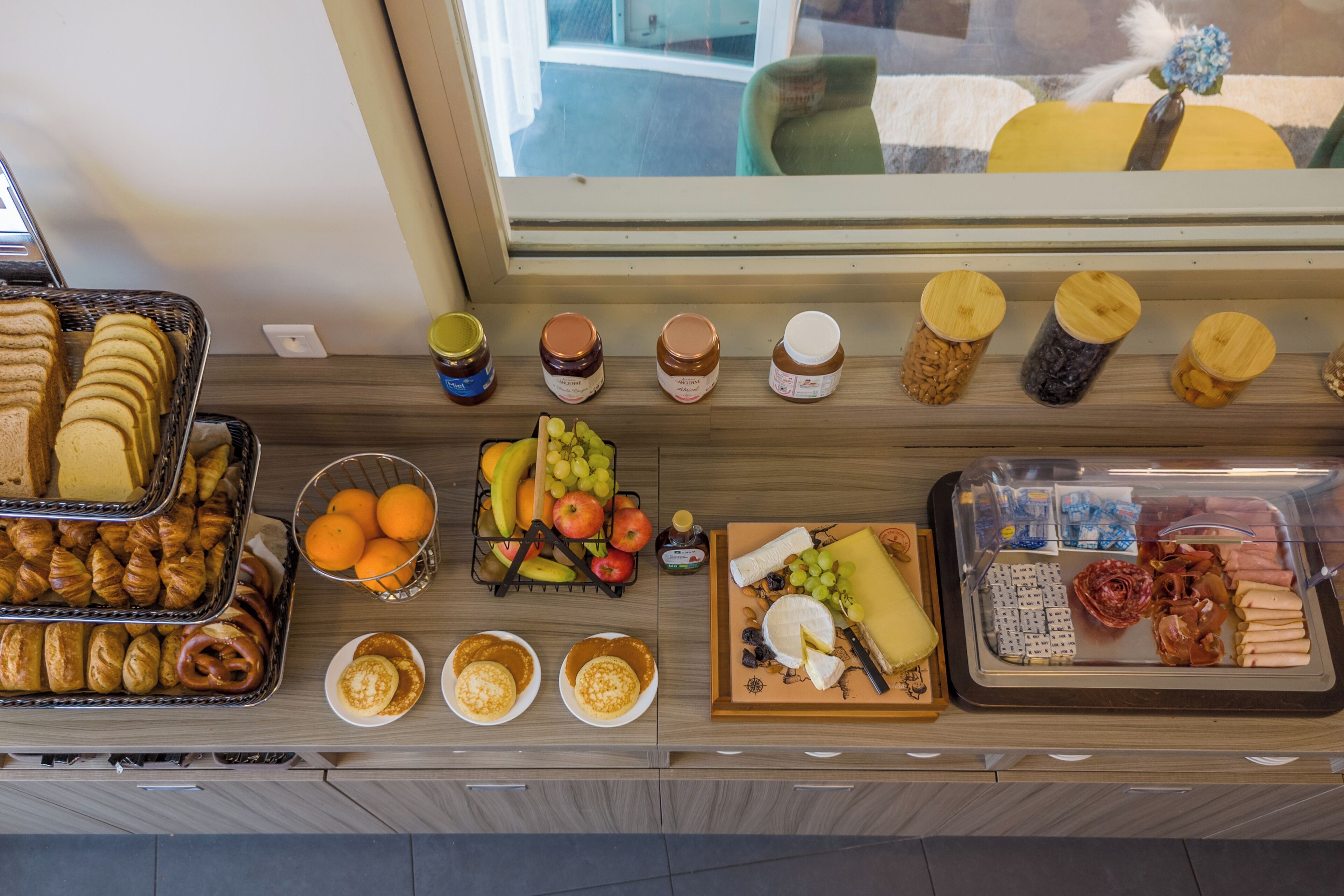 Un bufé con diversos alimentos, incluyendo pasteles, frutas, quesos y carnes.