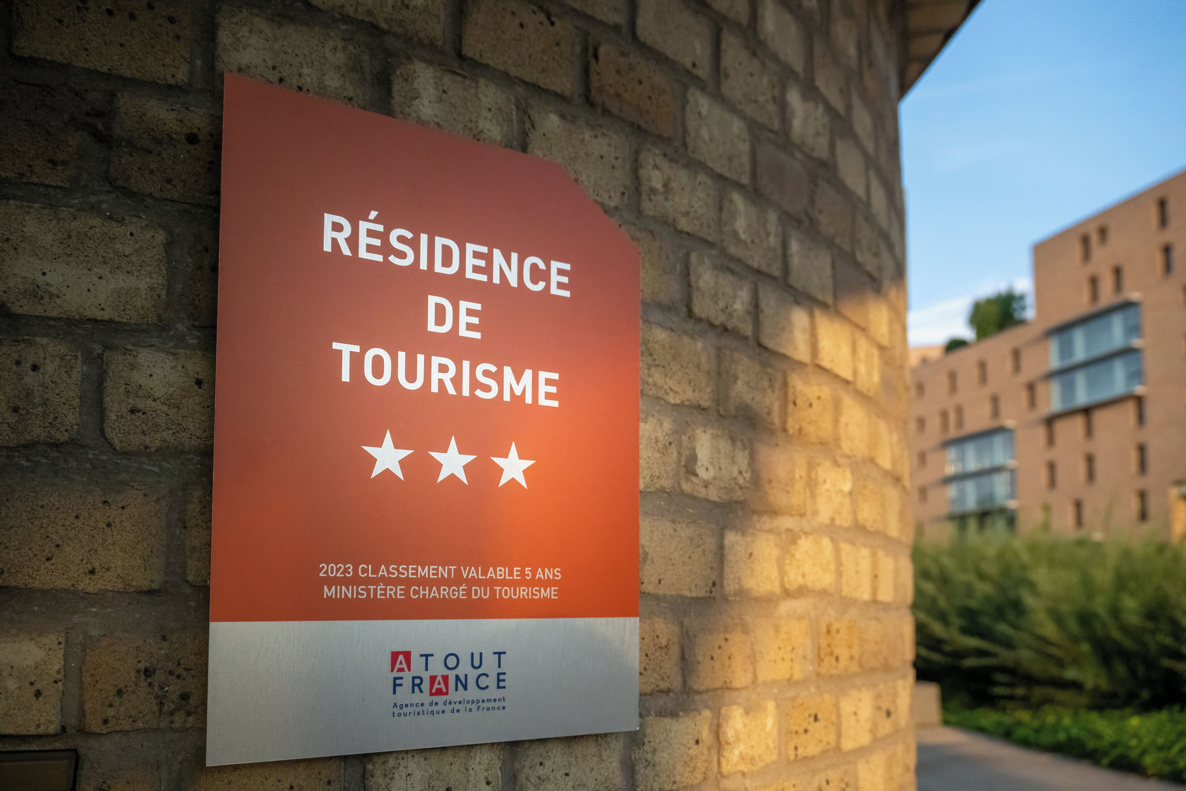 A sign indicating a 'Résidence de Tourisme' with a 5-star rating, associated with the 'Atout France' agency.