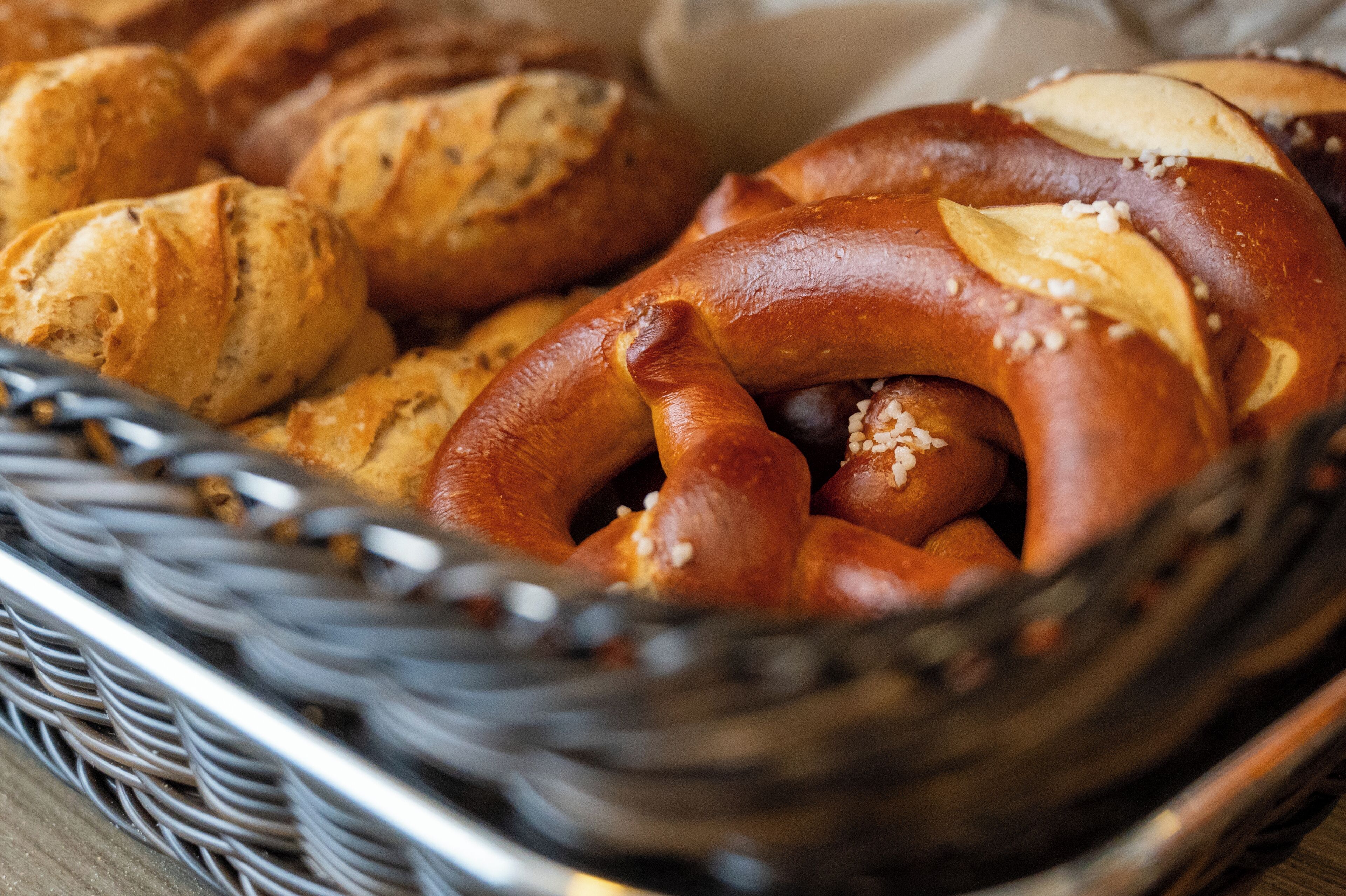 Ein Korb mit verschiedenen Backwaren, darunter Brezeln und Brötchen.