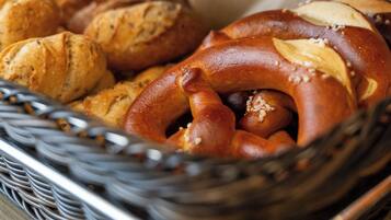 Un cesto con diversi prodotti da forno, tra cui pretzel e panini.