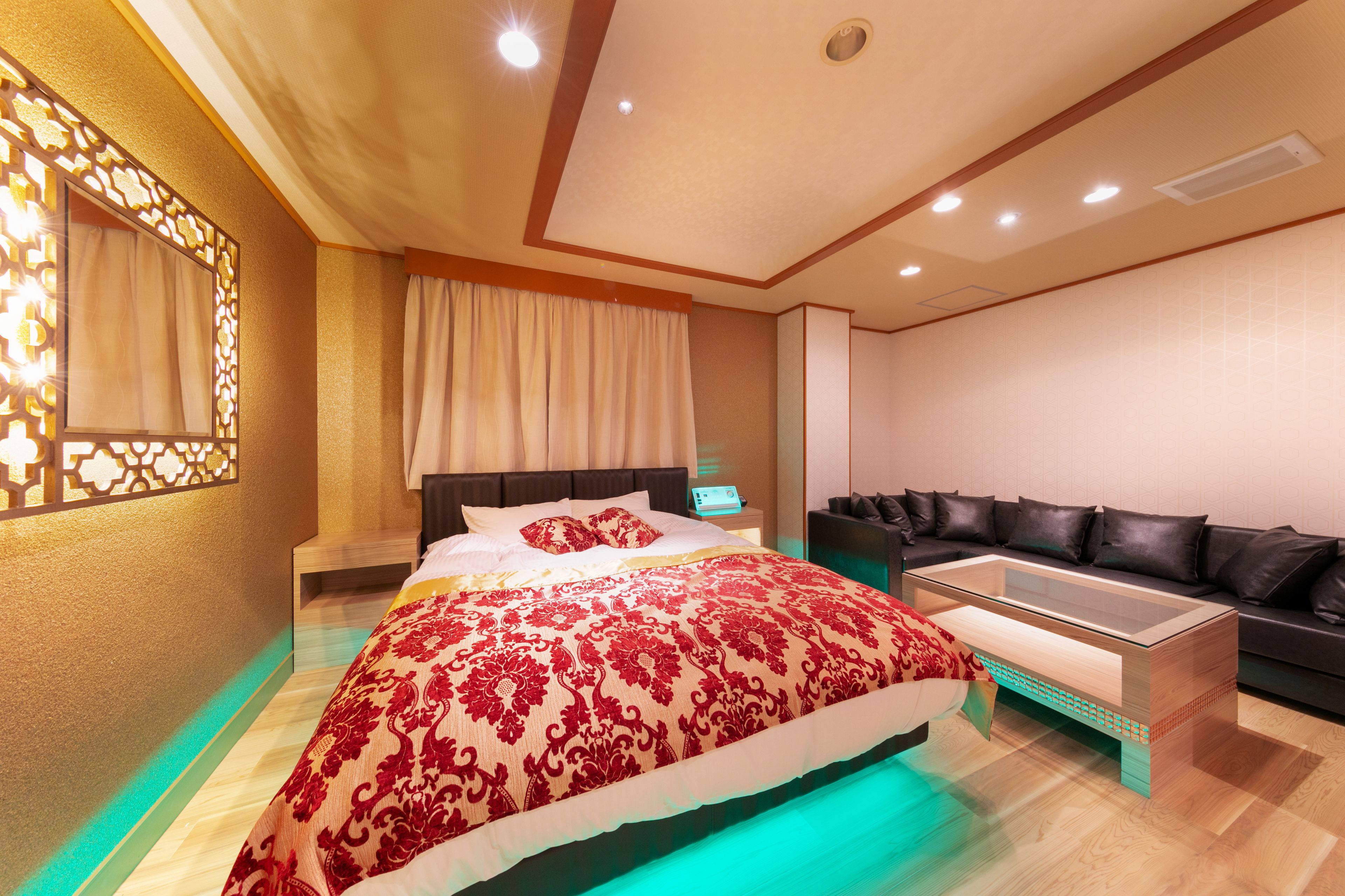 Een moderne slaapkamer met een groot bed, een bank en een glazen bijzettafeltje.