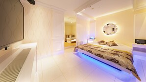A modern bedroom with a large bed, a TV, and a bathroom visible in the background. - i RESORT ARTIA Luxury GIFU - Adult only (Gifu)