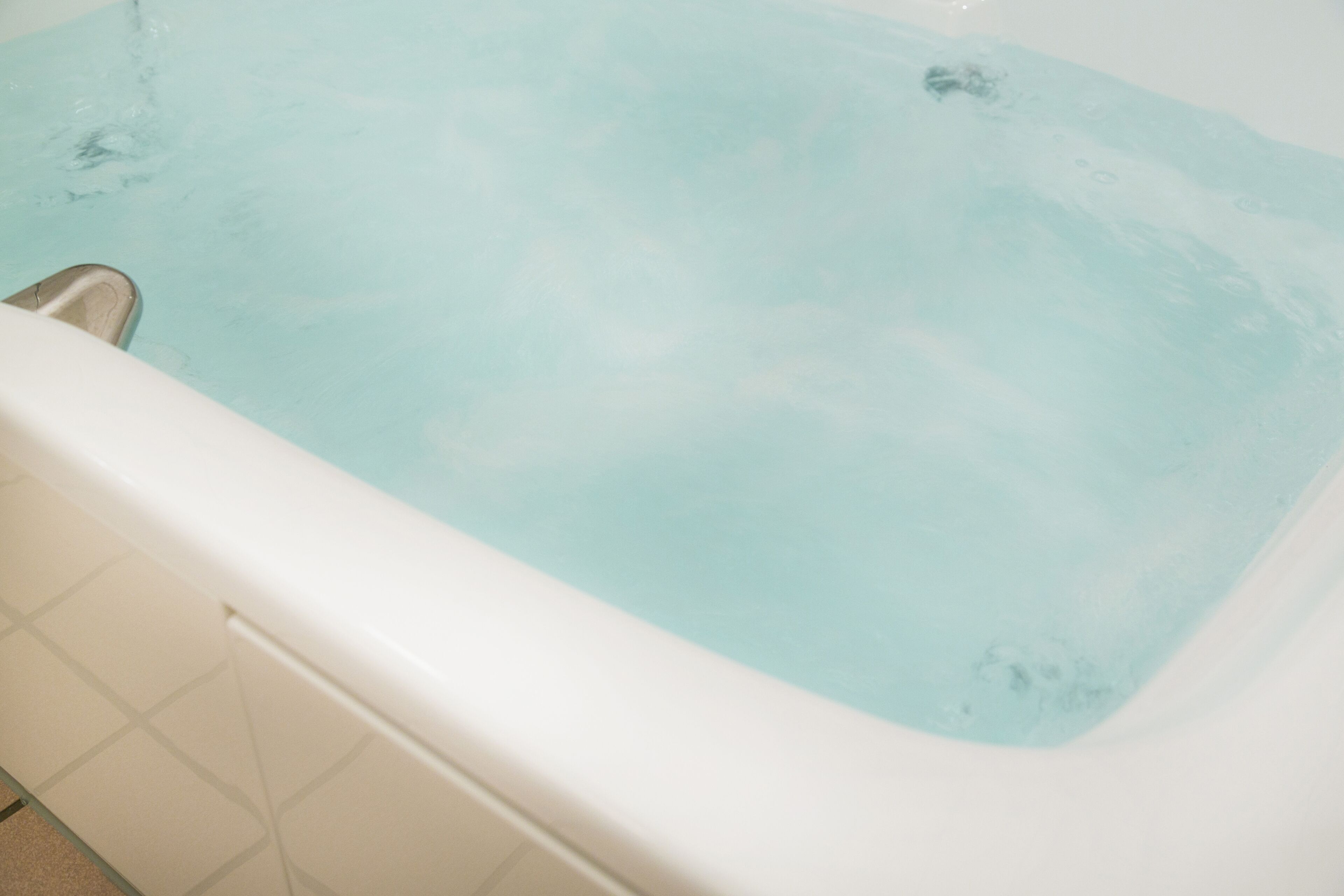 A bathtub filled with clear water.