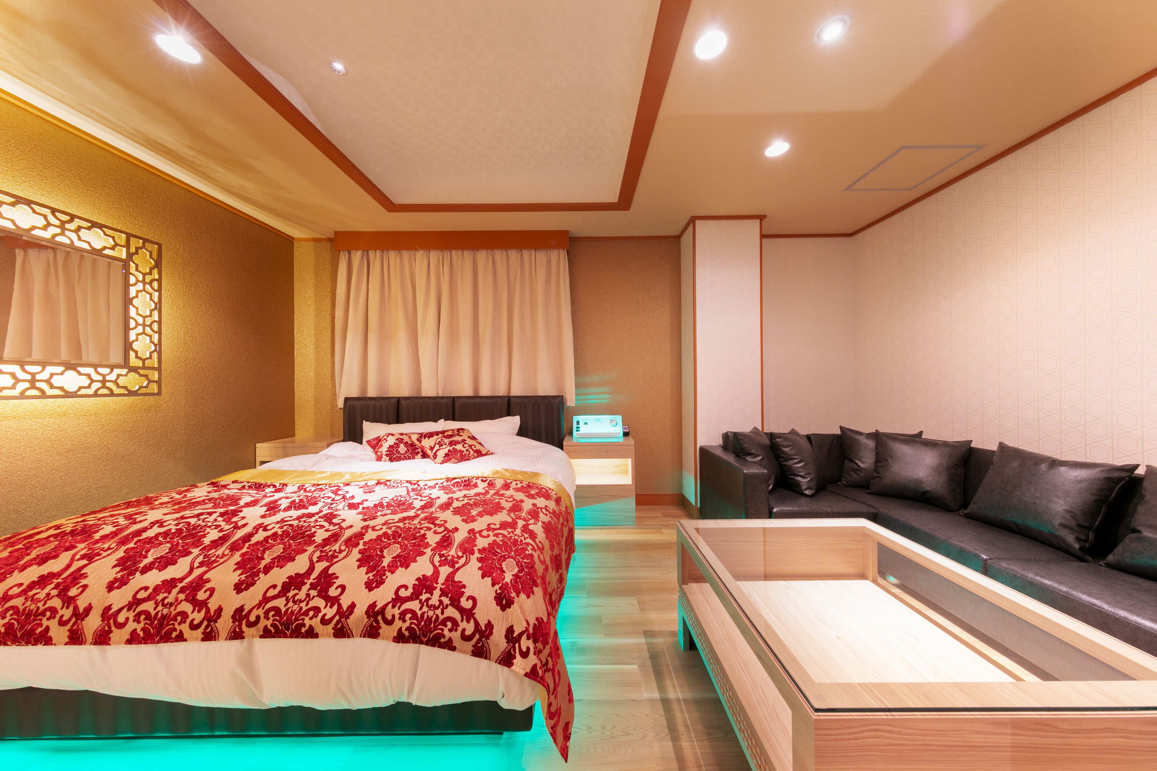 Un dormitorio moderno con una cama grande, un sofá y una mesita de noche.