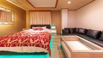Un dormitorio moderno con una cama grande, un sofá y una mesita de noche.