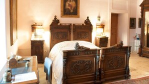 A traditional room with a large bed, wooden furniture, and a painting on the wall. - Masseria Murgia Albanese (Noci)