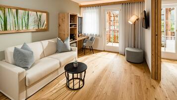 Un salon moderne avec un canapé blanc, une petite table ronde et un plancher en bois.