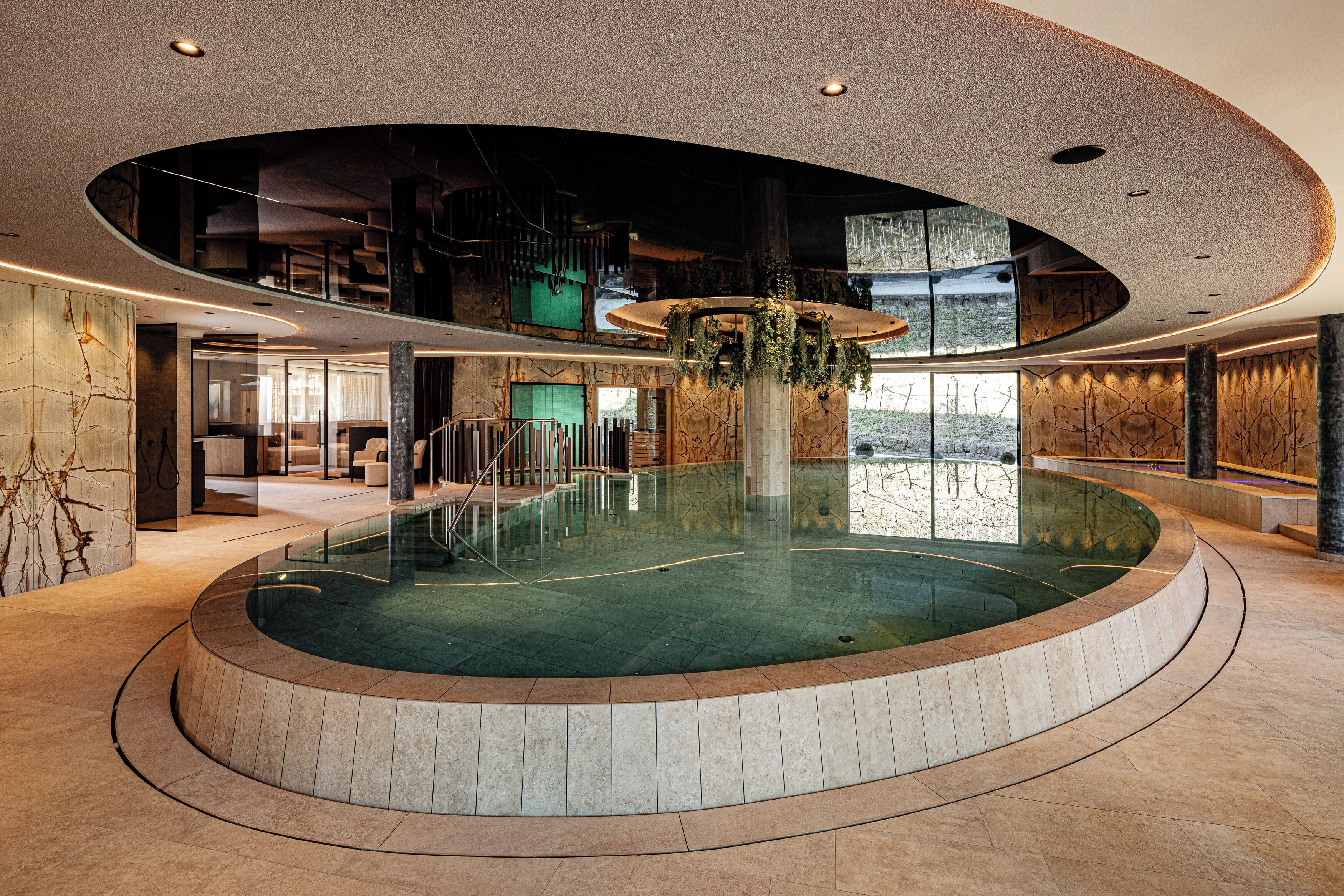 Una piscina techada, una piscina al aire libre, sombrillas