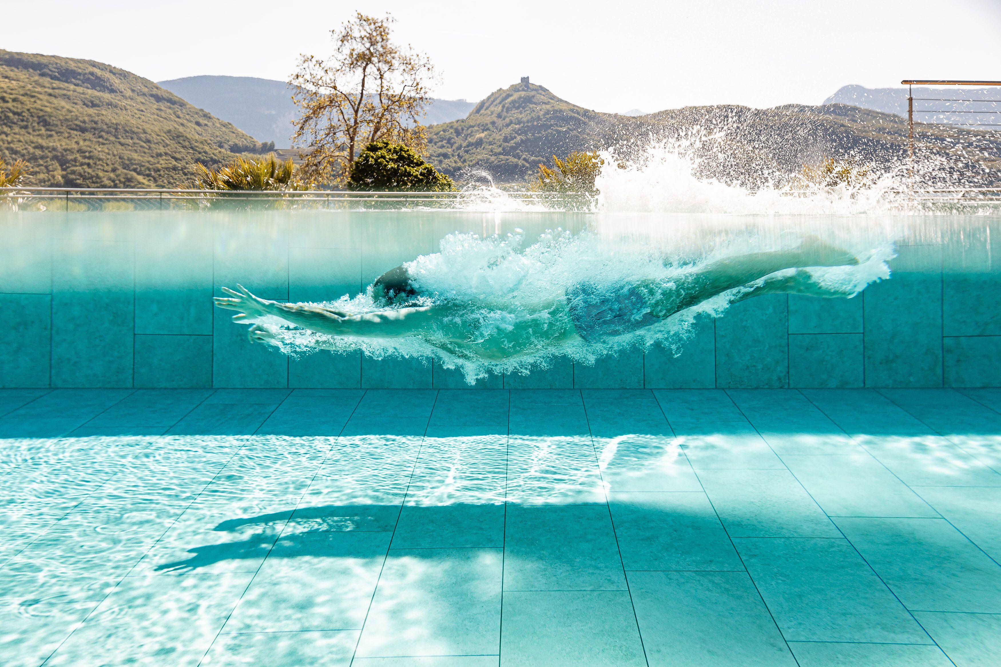 Alberca techada, alberca al aire libre y sombrillas en la alberca