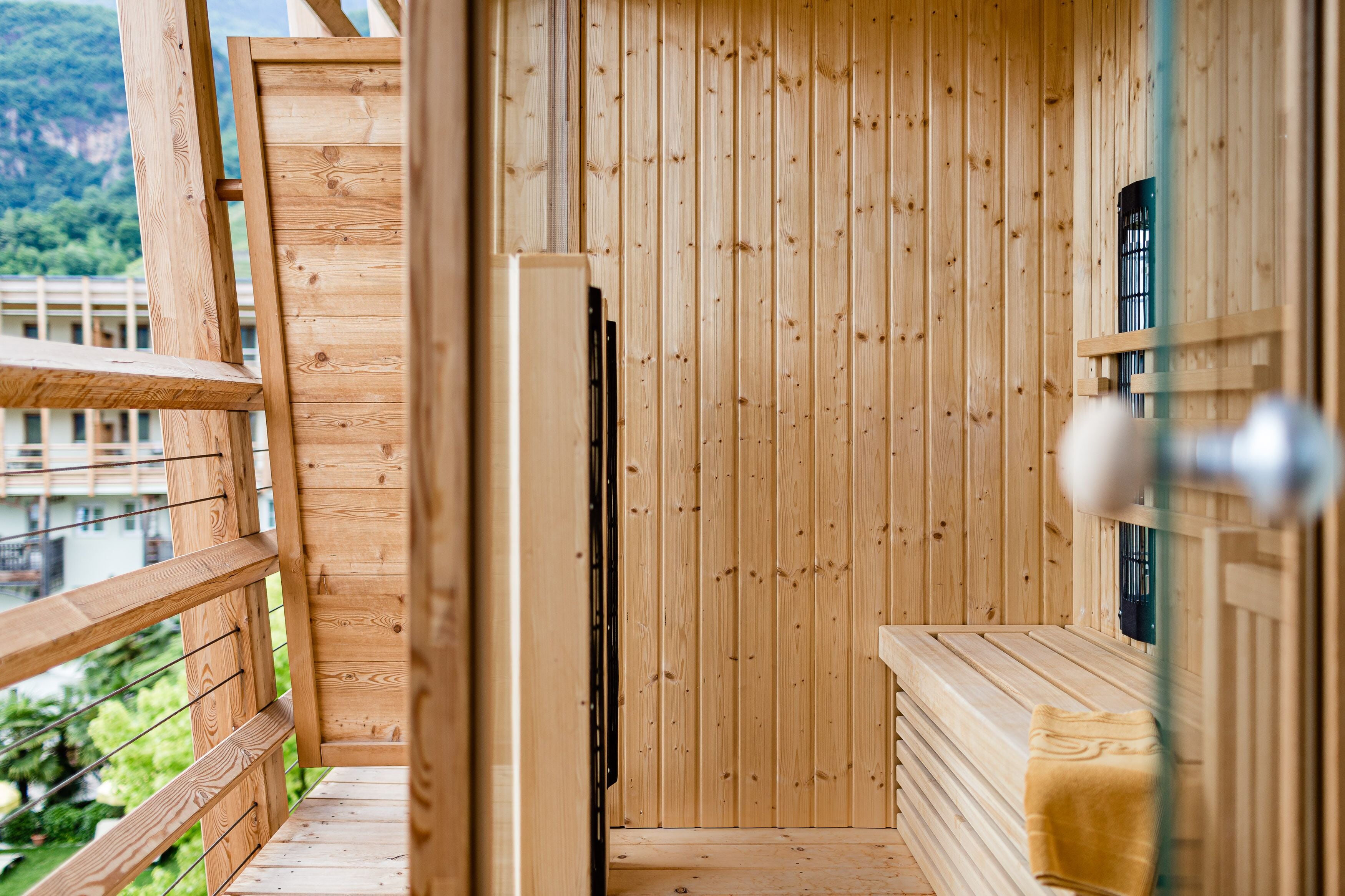 A wooden sauna room with a bench and a window.