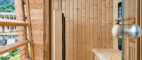 A wooden sauna room with a bench and a window.