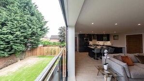 A modern apartment with a balcony, a kitchen, and a living area. - Ivory Lodge (Reading)