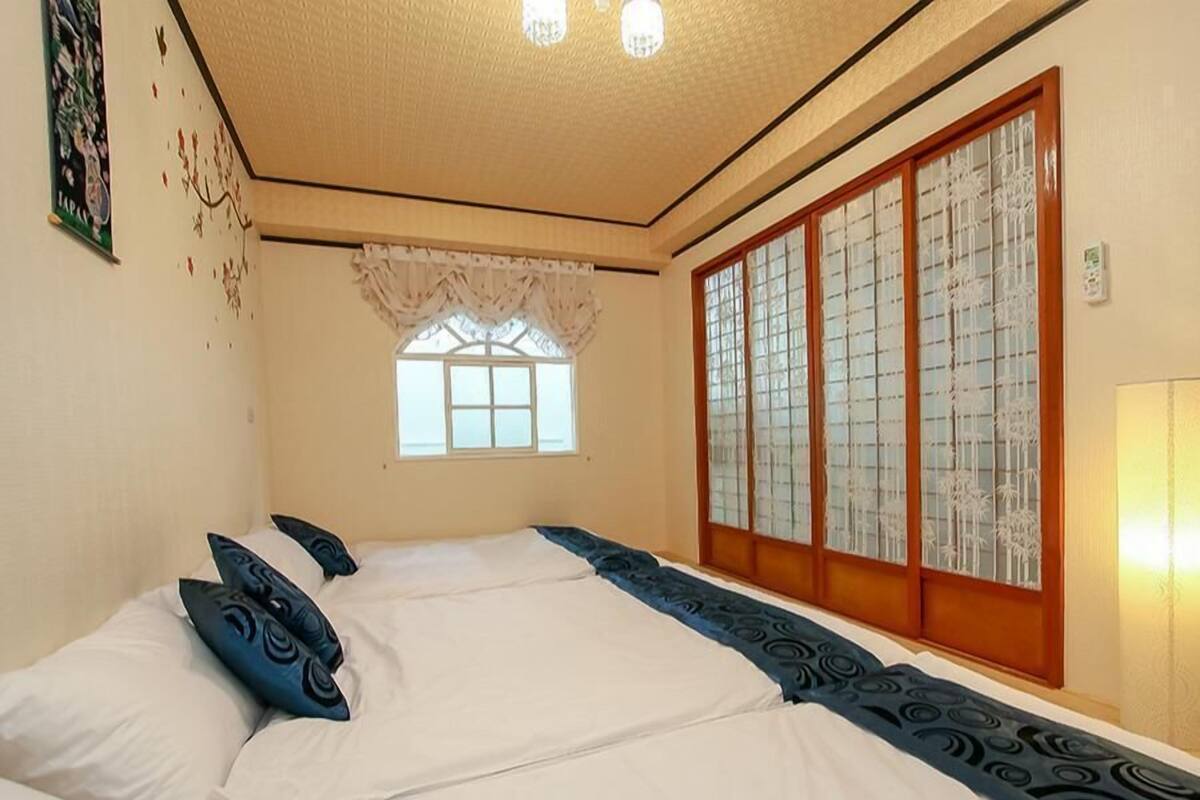 A traditional Japanese-style room with tatami flooring, a low ceiling, and sliding shoji doors.